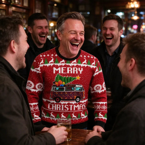 Man laughing with friends in a red funny christmas jumper at a pub