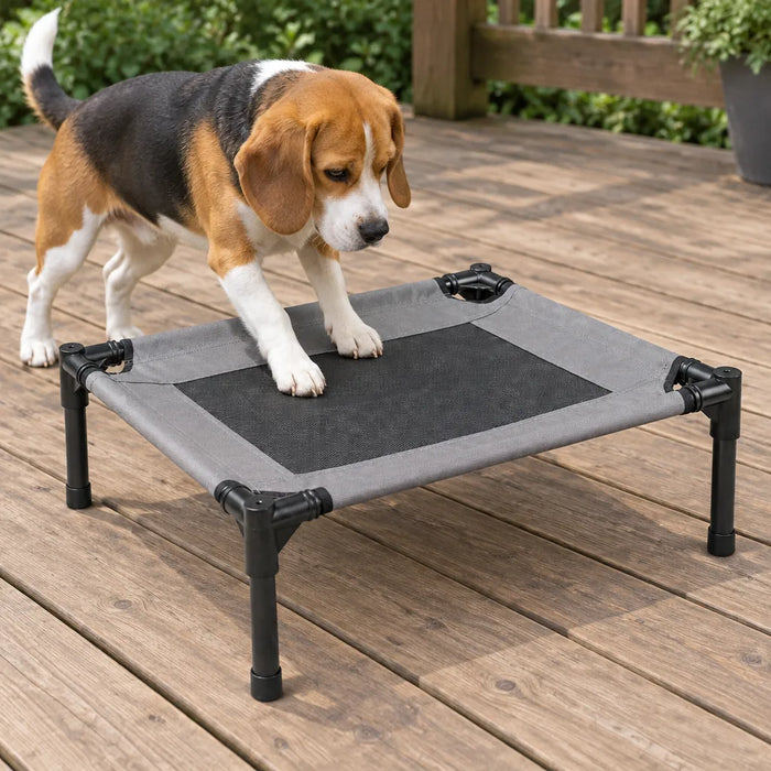 Beagle stepping onto the mesh of an outdoor dog bed on a wooden deck