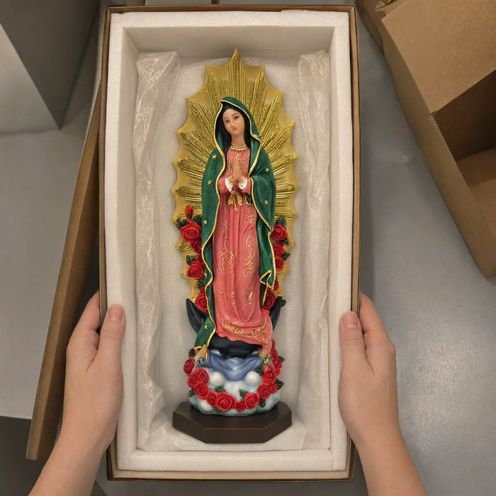 Hands lifting the Virgen de Guadalupe statue out of its protective packing