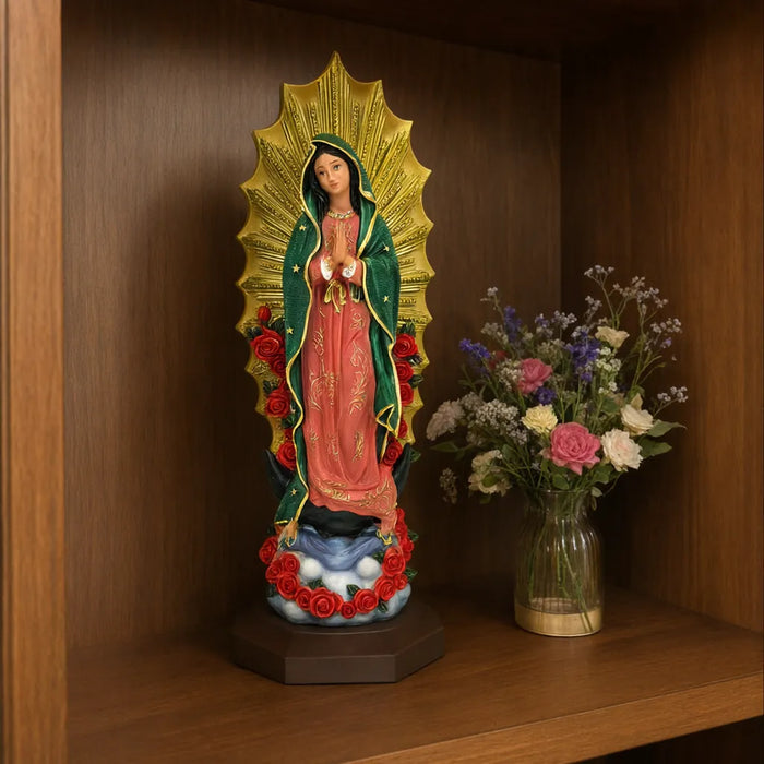 Our Lady of Guadalupe statue on a wooden shelf next to a vase of flowers