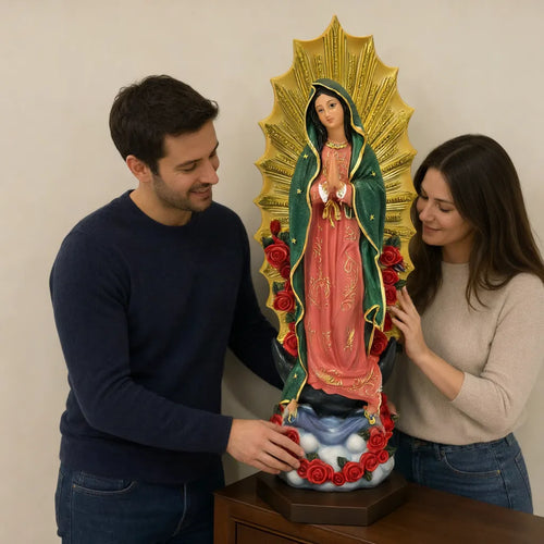 Couple smiling beside an Our Lady of Guadalupe statue on an entryway table
