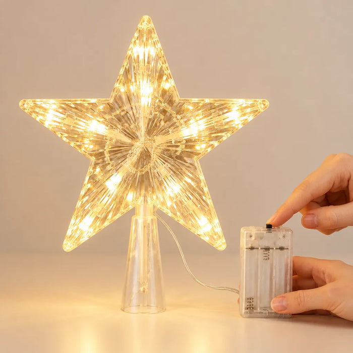 Finger pressing the switch on the battery box of a light up tree topper