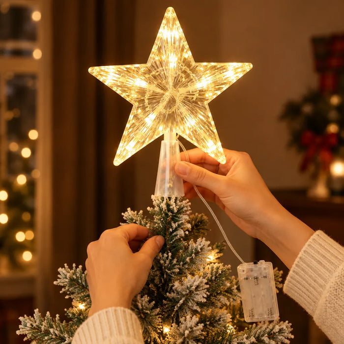 Hands sliding the cone base of a star tree topper onto a Christmas tree branch