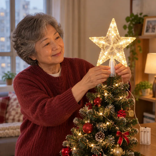 Older woman placing a light up tree topper on a small apartment Christmas tree