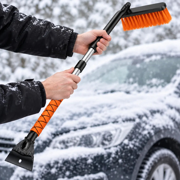 Mains déployant le manche en aluminium d'un balai à neige télescopique près d'une auto enneigée