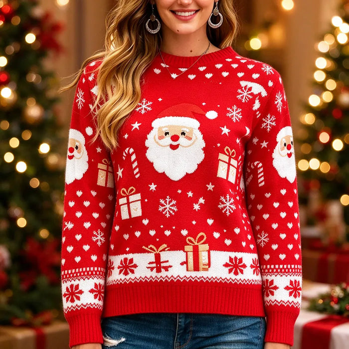 Smiling woman in a red Santa Christmas jumper beside a lit Christmas tree