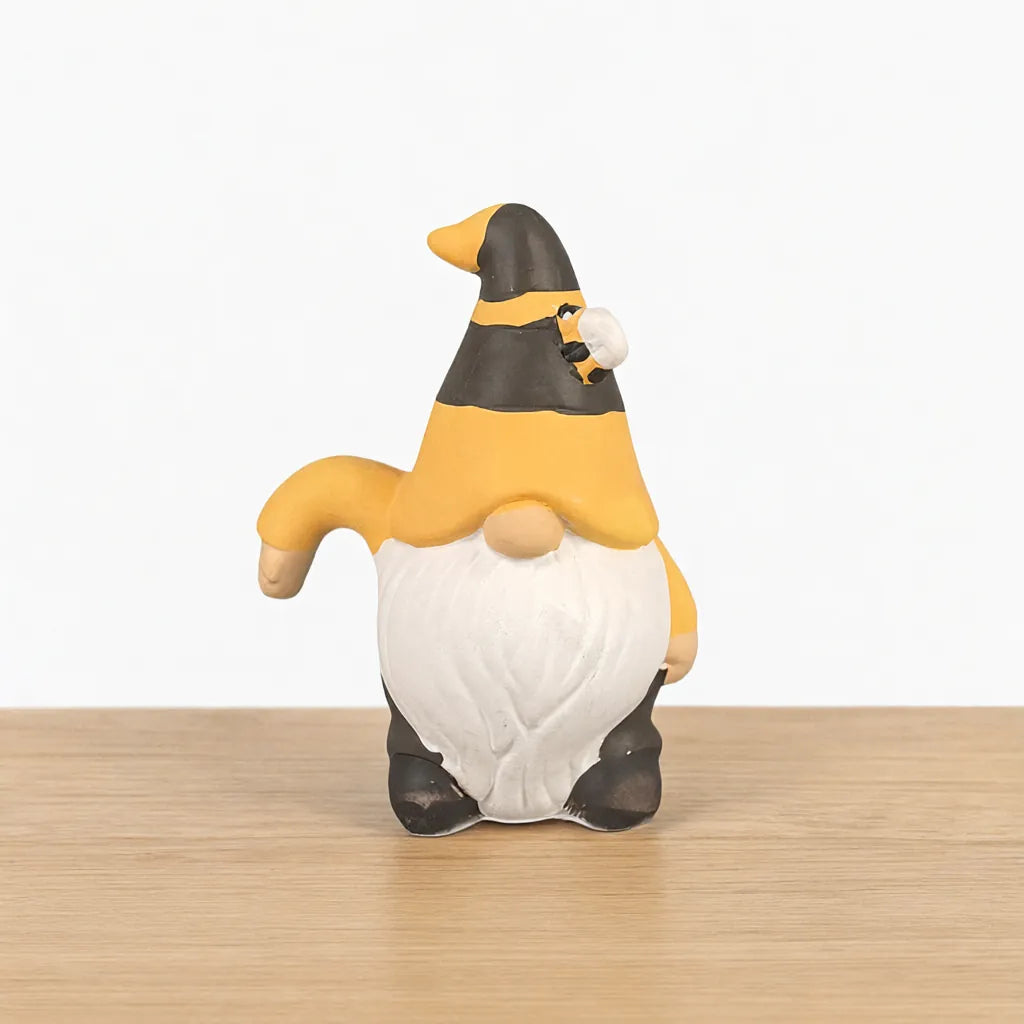 One ceramic bee garden gnome figurine on a light wooden surface