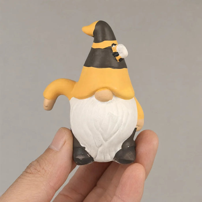 Hand holding a small ceramic garden gnome statue, about 4.4 inches tall