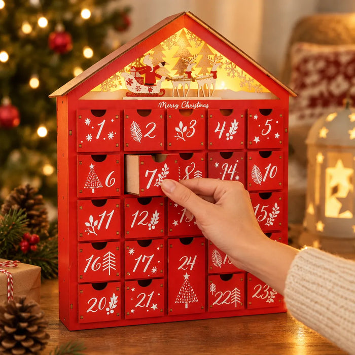 Mano cerrando un cajón numerado del calendario de adviento de madera roja
