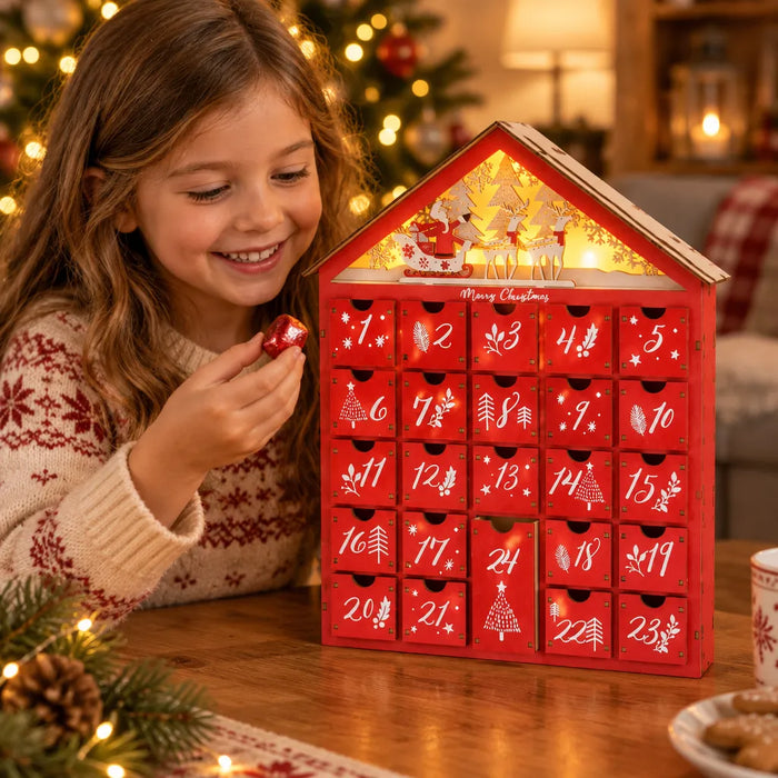 Niña sonriente con un detalle del calendario de adviento de madera para la cuenta regresiva de Navidad