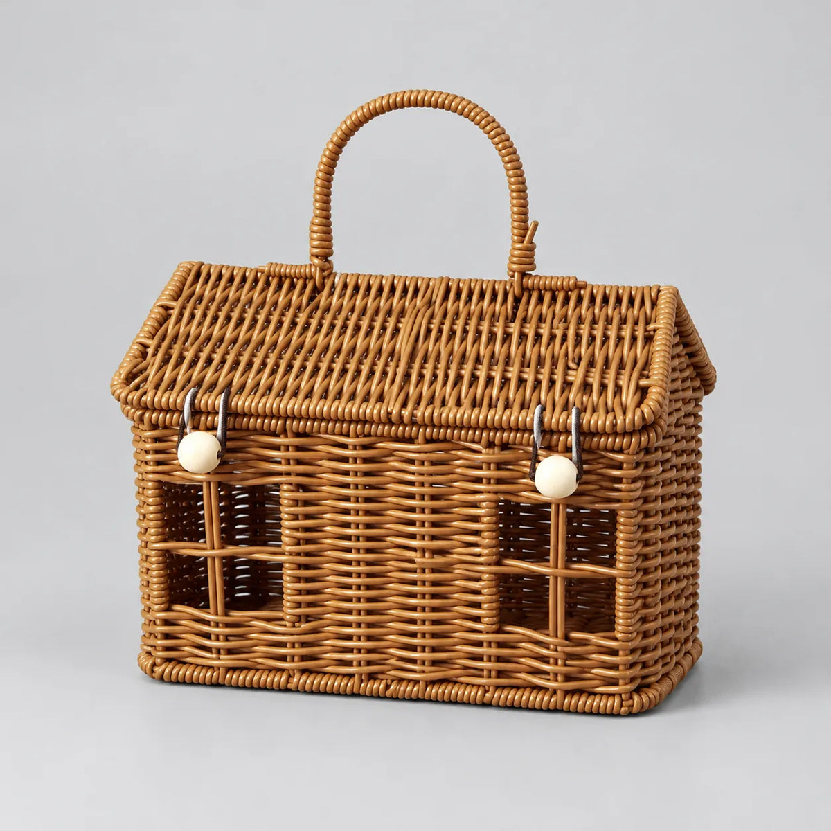 One empty woven hamper basket with hinged lid and handle on a grey surface