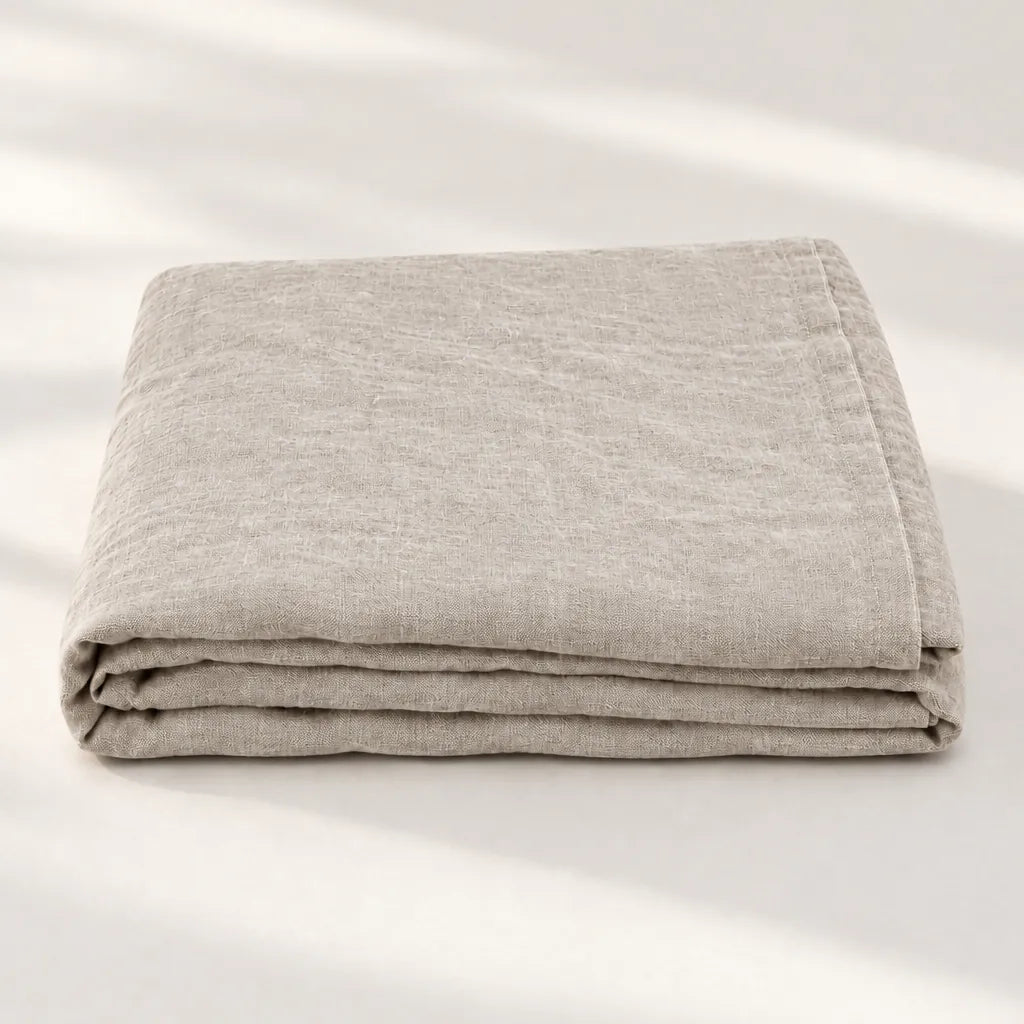 One folded natural linen flat sheet on a light surface