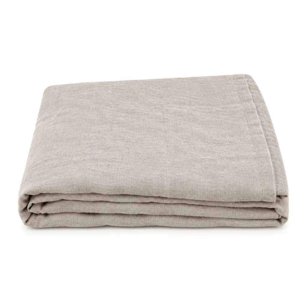 Folded natural linen flat bed sheet on a white background