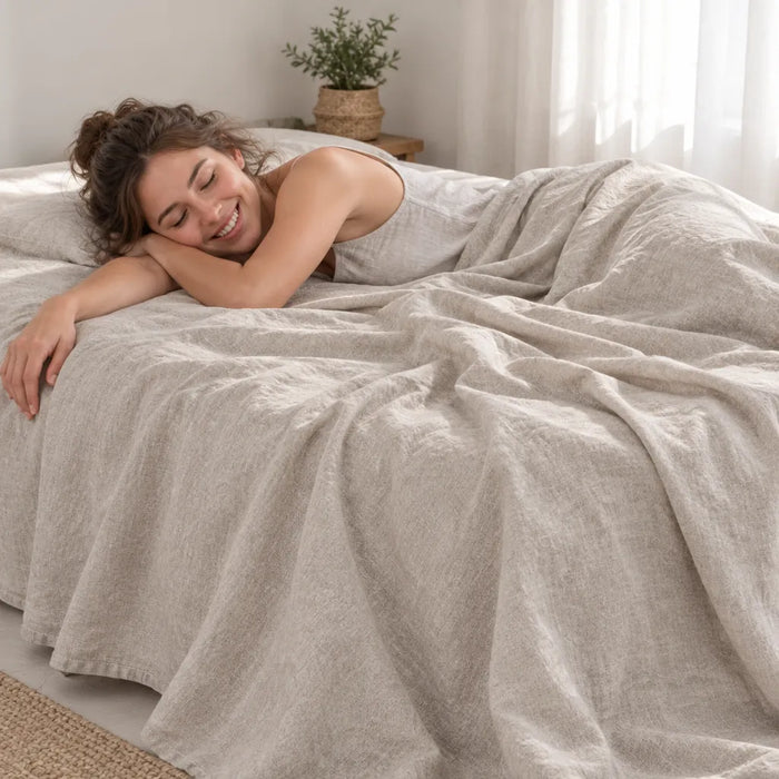 Smiling woman resting on a bed with a natural linen sheet